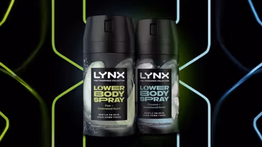 Two Lynx lower body spray bottles side by side, featuring Pear and Cedarwood scent, and Coconut and Sandalwood scent, against a neon background.