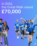 Smiling colleagues in blue Great Walk shirts celebrate raising £70,000 in 2026.
